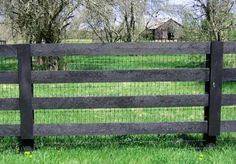 a black fence in front of a grassy field