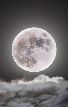 the full moon is shining brightly in the dark sky above some fluffy white clouds on a cloudy night