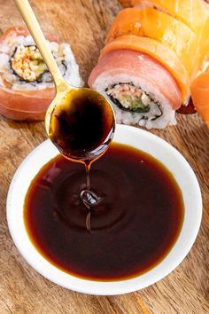 the sauce is being drizzled onto sushi rolls