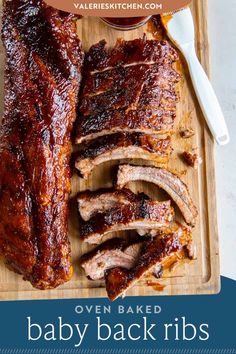 baby back ribs on a cutting board with the words oven baked baby back ribs above it