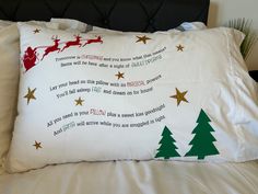 a christmas pillow on a bed with santa's sleigh and tree decorations