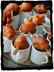 small cups filled with food sitting on top of a glass plate covered in toothpicks