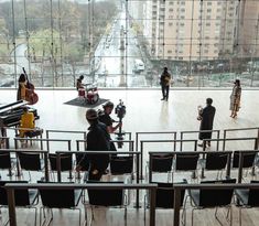 a group of people standing around in front of a window with musical instruments on it