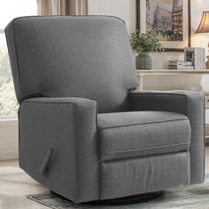 a gray reclining chair sitting on top of a rug in a living room next to a window