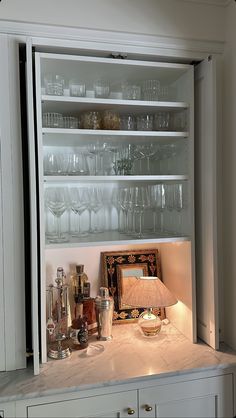 an open cabinet filled with glasses and other items