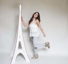 a woman posing in front of the eiffel tower with her legs spread out