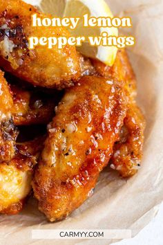 honey lemon pepper wings on a plate with lemon wedges in the background and text overlay