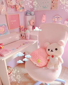 a teddy bear sitting on top of a pink chair next to a white desk and wall