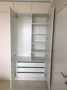 an empty white closet with drawers and shelves