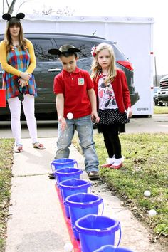 three children playing with buckets on the sidewalk