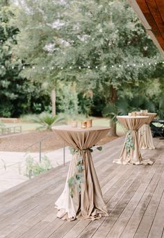 the tables are set up on the deck for an outdoor wedding reception in front of some trees