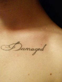 a woman with a tattoo that says damaged on her chest and the word's name written in cursive font