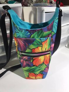 a multicolored floral purse sitting on top of a white counter next to a freezer