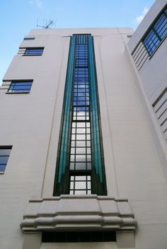 the side of a tall building with windows and bars on it's bottom floor