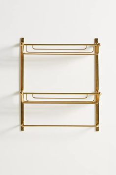 two gold towel racks against a white wall