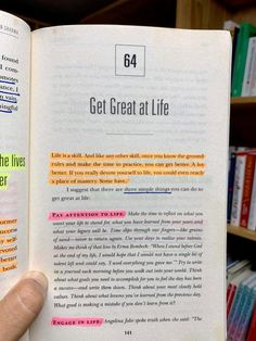 someone is holding up a book in front of bookshelves with text on it