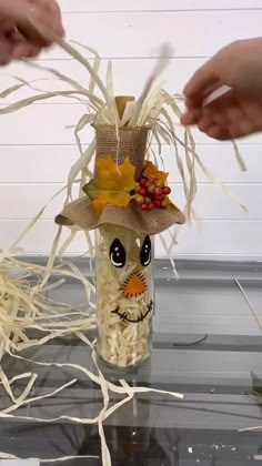 someone is making a scarecrow decoration out of shredded white paper and plastic straws