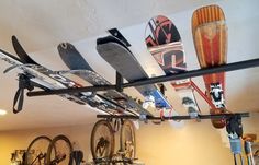 there are many skis and snowboards hanging from the ceiling