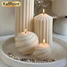 three candles sitting on top of a white plate