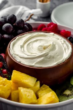 a white bowl filled with fruit and dip