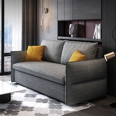 a living room with a gray couch and yellow pillows on the armrests in front of a large window