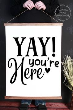 a person holding up a sign that says yay you're here