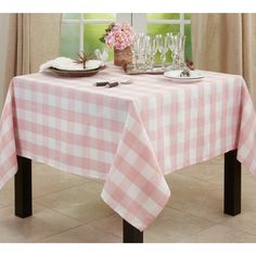 a table with a checkered cloth on it and wine glasses sitting on the table