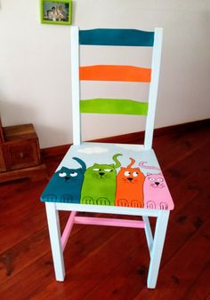 a wooden chair painted with colorful cats on it