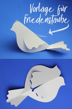 an origami bird is cut out of paper and placed on a blue background