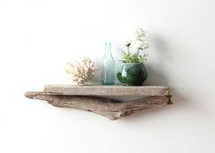 two wooden shelves with vases and flowers on them