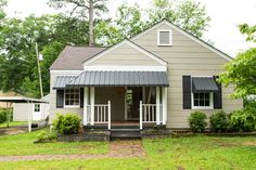 a small gray house with black shutters