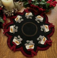 a black and red table mat sitting on top of a wooden table next to christmas decorations