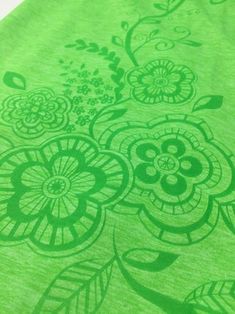 a green t - shirt with flowers and leaves on it