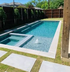 an empty swimming pool in the middle of a backyard with grass and stepping stones on the ground