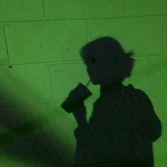 the shadow of a person drinking from a cup