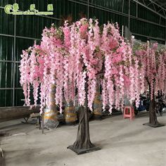 pink flowers are in vases on the floor next to other trees and barrels with beer kegs behind them