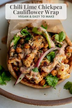 a white plate topped with a pita covered in meat and vegtables