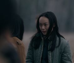 a woman standing next to another woman in a field