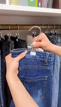 a woman is trying to open her jeans in front of some books on the shelf