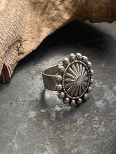 This is such a special stering silver (unstamped) ring that I had made from a vintage concho pin from the American Southwest. I cannot say for sure, but the pin (now the face of the ring)  is likely Navajo/Diné in origin. It is a solid and well made piece with a nice weight to it.  The face of the ring measures 1 inch in diameter. The band measures  5/16 inch wide. It is between size 6.25 and 6.5 but due to the wide band it fits snugly.  Weight: 12.8 g Unique Sterling Silver Concho Jewelry, Adjustable Antique Concho Jewelry, Antique Adjustable Concho Jewelry, Vintage Silver Concho Ring, Antique Silver Concho Jewelry, Western Sterling Silver Concho Rings, Western Style Sterling Silver Concho Rings, Silver Concho Rings Perfect For Gifts, Silver Concho Rings For Gift