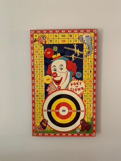 a painting on the wall of a clown holding a dart