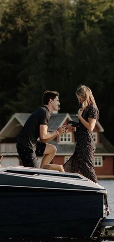 a man and woman standing on top of a boat in the water next to each other