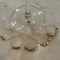 four wine glasses sitting on top of a table next to a wine glass with five small gold stars in it