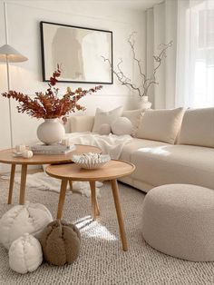 a living room filled with furniture and a vase on top of a wooden coffee table