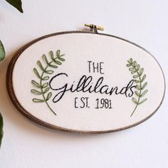 embroidered sign hanging on the wall that says the gilllands est 1, 1908 with green leaves