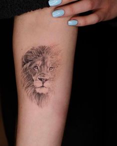 a woman's arm with a lion tattoo on it