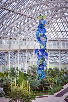 a tall blue glass sculpture in a building