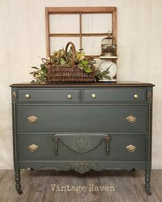 an old dresser painted green with gold trimmings and flowers in the top drawer