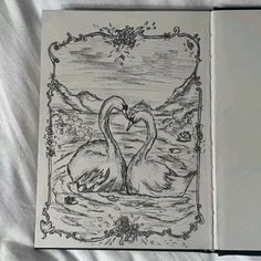 an open book with two swans in the water and one is holding it's heart