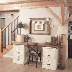 a white desk with two drawers under a wooden stair case in a living room next to a staircase